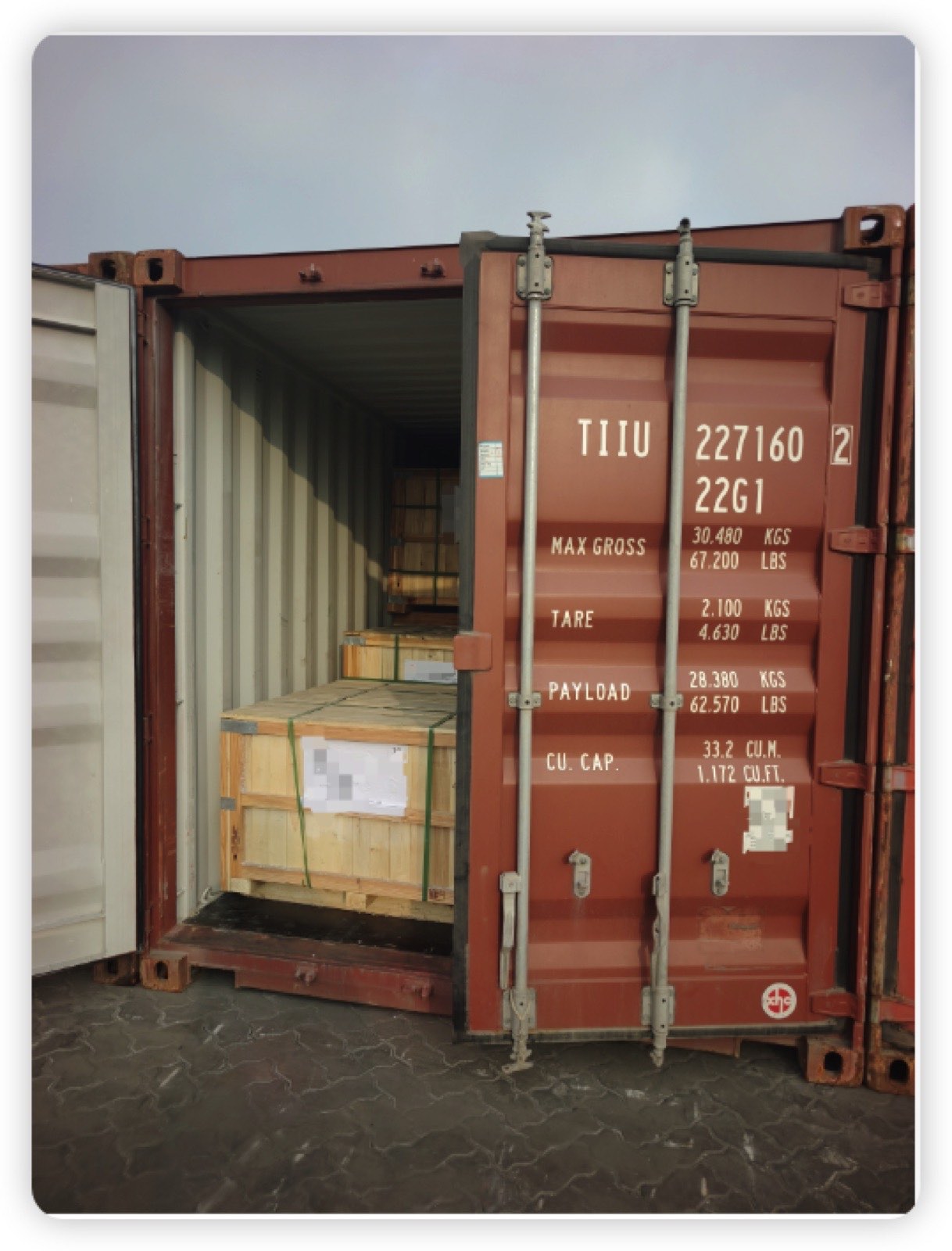 Crates staged beside a 20-foot container at a load point